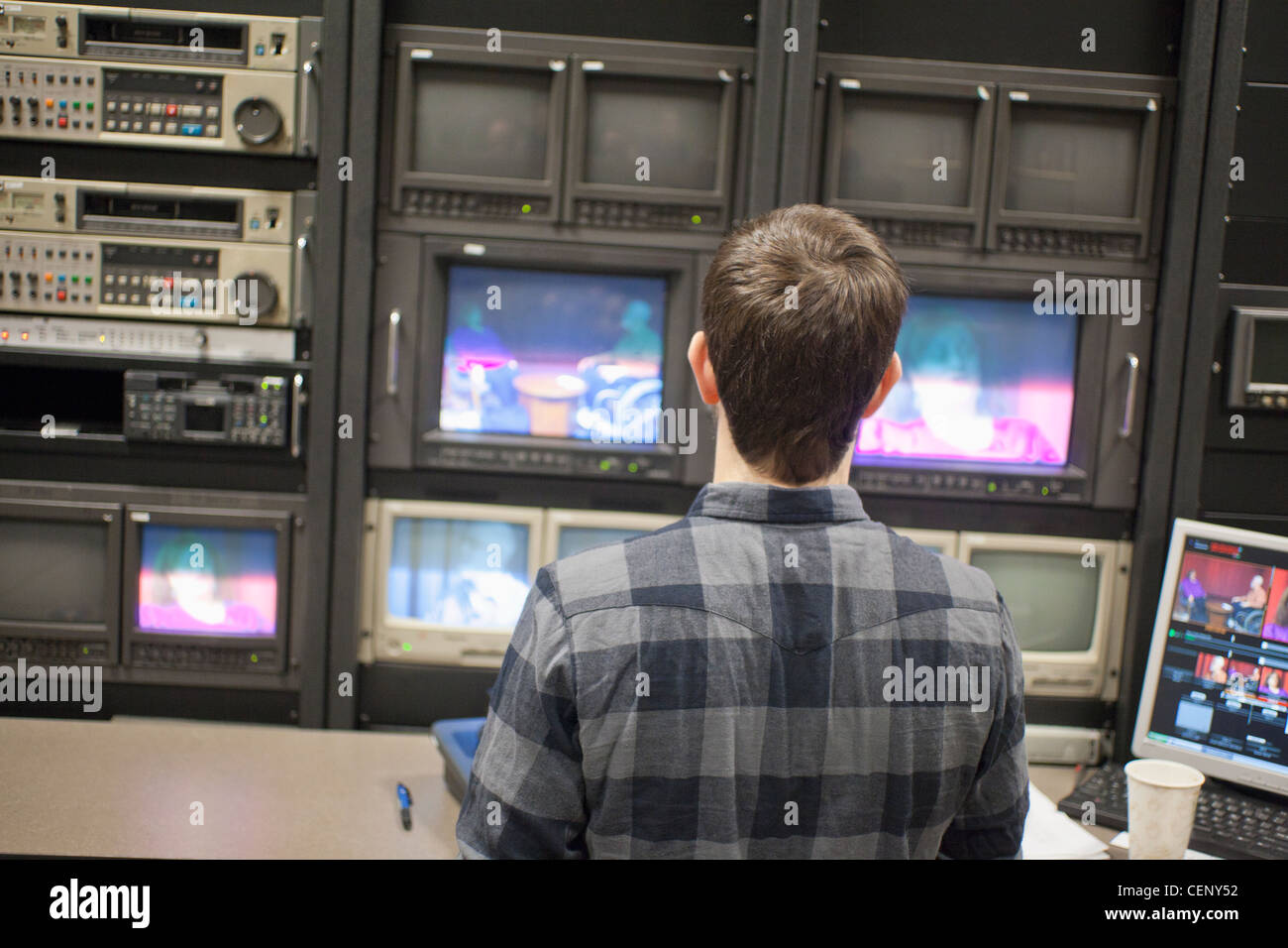 Video-Editor bei der Arbeit in einem TV-Kontrollraum in einem Kabel-TV-Studio bearbeiten Stockfoto