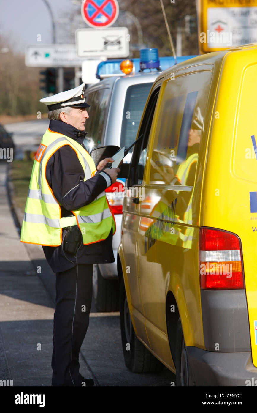 Polizeikontrolle, Verkehr Drehzahlregelung, Polizist stoppt Autos auf einer Straße. Stockfoto