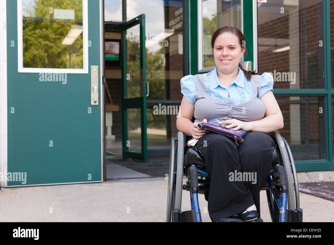 Student im Rollstuhl verlassen Schuleingang Stockfoto