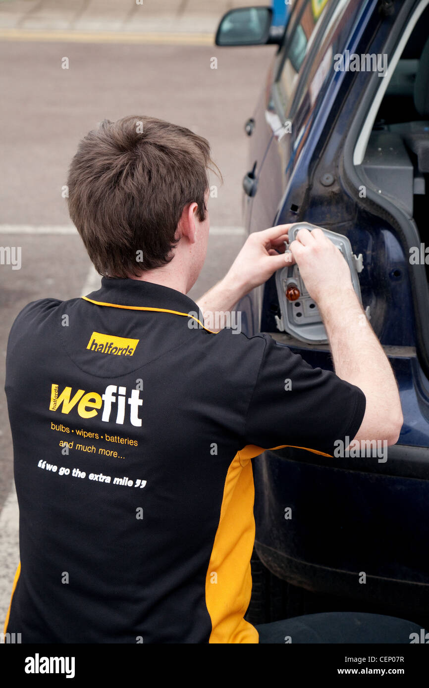 Ein Halfords Mitglied des Personals, die Montage einer Glühbirne zu einem Kunden Auto, Newmarket Suffolk UK Stockfoto
