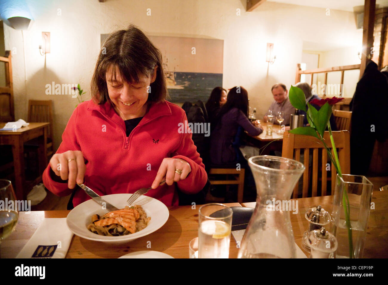 Eine Frau, die eine Fisch-Mahlzeit in einem Loch Fyne Restaurant, Cambridge UK Stockfoto