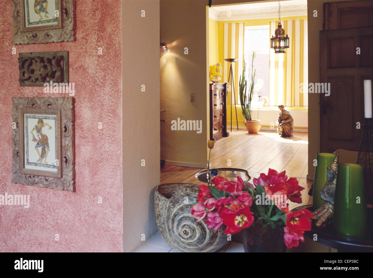 Blick zum großen Wohnzimmerfenster und Holzboden Wand im Vordergrund texturiert Maleffekt, alt gerahmt Kunstwerke und Topf Stockfoto