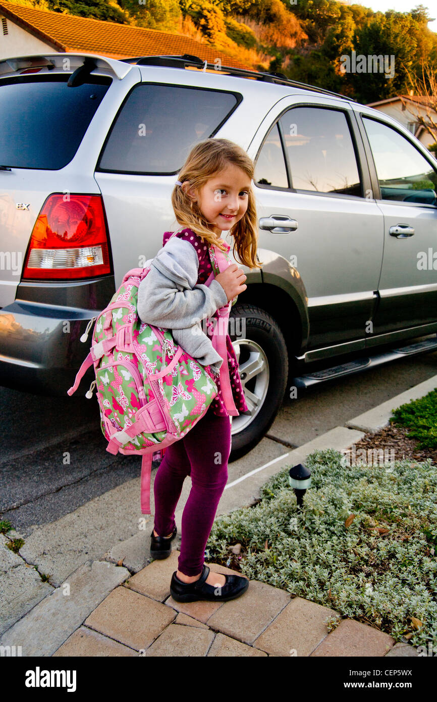 Tragen ihren Rucksack und Lunch-Box, wartet ein 6 Jahres altes Mädchen mit dem Auto zur Schule in San Juan Capistrano ca. Model Release gehen Stockfoto