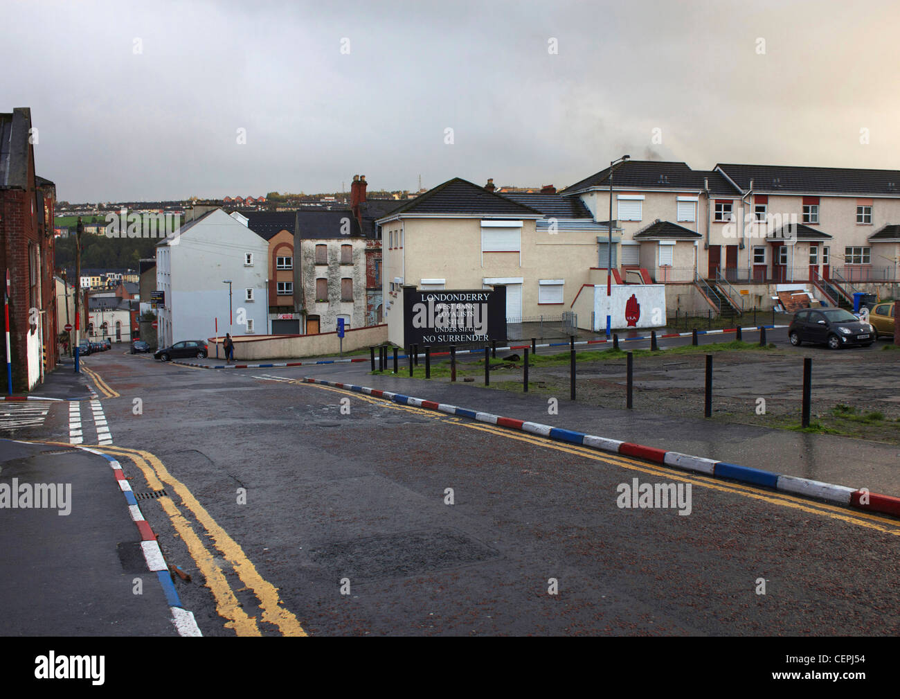 Ein trotzigen Zeichen und Bordstein Steinen in rot, weiß und blau im protestantischen Bereich von Derry, Londonderry, Nordirland gemalt. Stockfoto