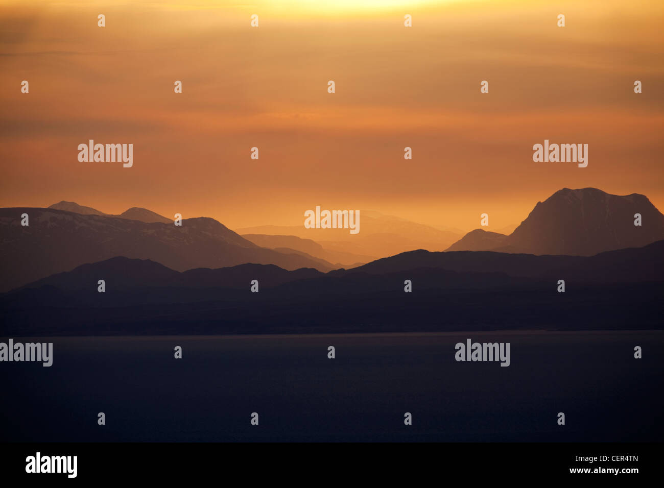 Ein Blick auf den Sonnenaufgang von der Quiraing in Richtung der fernen Hügel auf dem Festland. Stockfoto