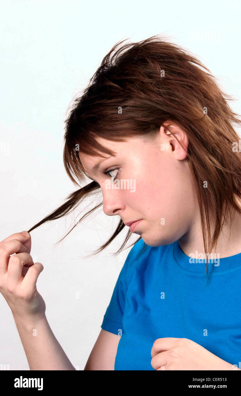 Profil von weiblichen Schulter Länge brünette Haare Fransen tragen Blau-t-Shirt blickte auf die Enden der Haare nach unten gedrehten Mund Stockfoto