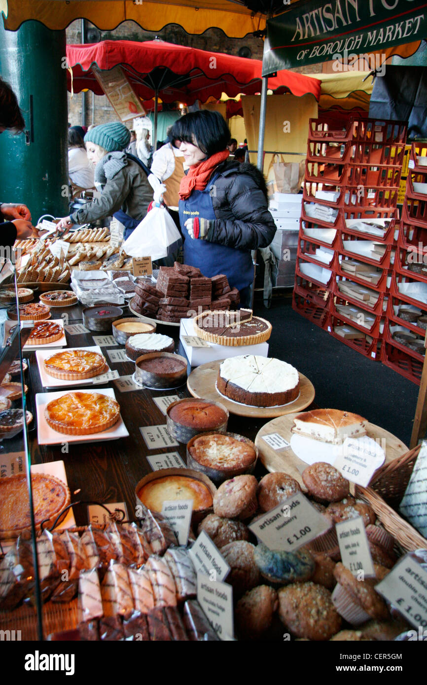 Mitarbeitende, die Dienstleistungen von einem Kuchen stall im Borough Market. Stockfoto