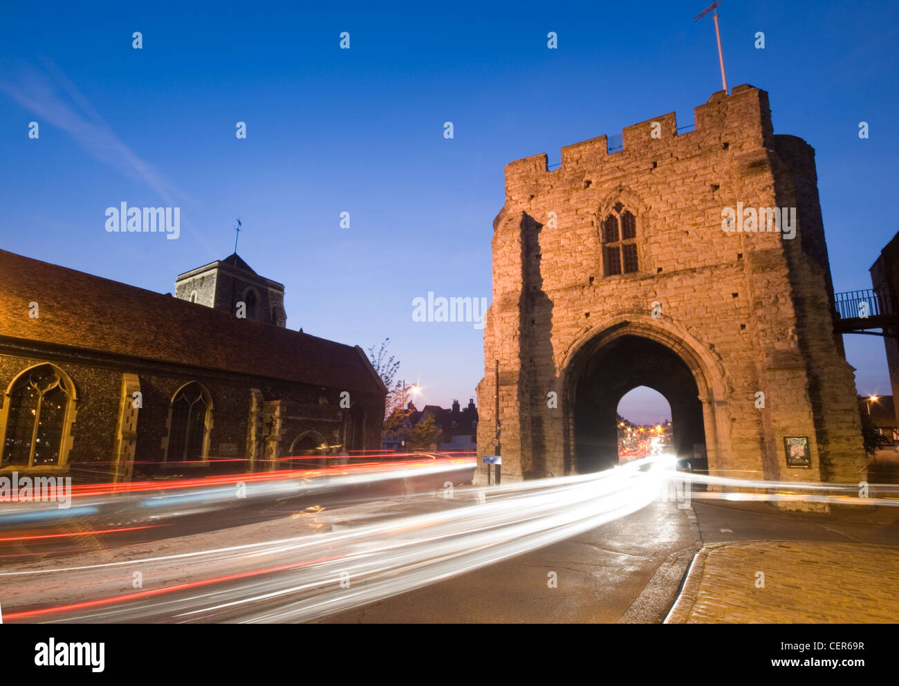 Der Westgate Tower in Canterbury beleuchtet in der Nacht mit Studien des Lichts vom Durchgangsverkehr. Stockfoto