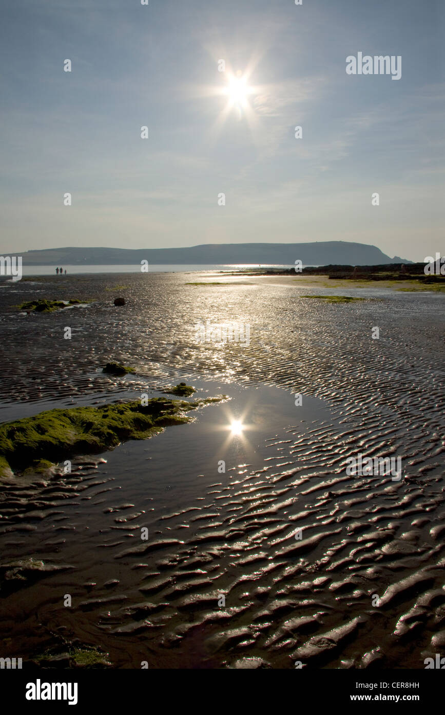Die Sonne spiegelt sich in einer Lache des Wassers am Strand in Daymer Bay in der Nähe von Trebetherick, North Cornwall. Stockfoto
