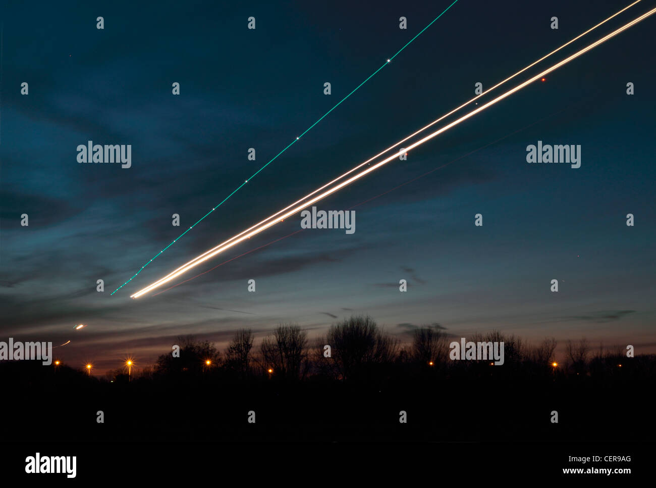 Lichtspur aus einem Flugzeug kommen, um in der Dämmerung am Flughafen Heathrow landen. Stockfoto