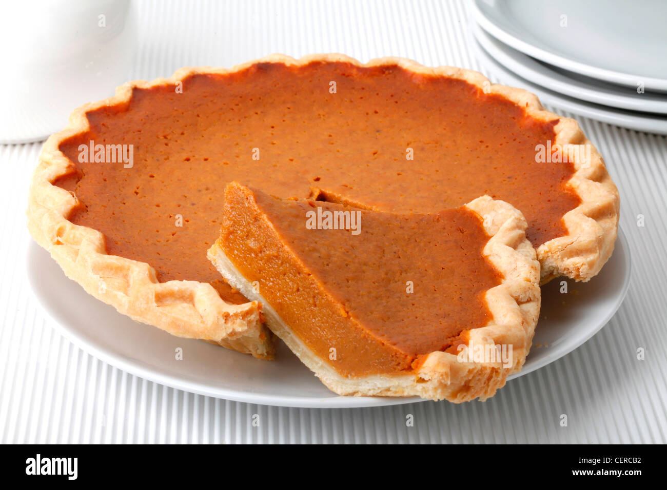 GESAMTE KÜRBISKUCHEN MIT GESCHNITTENEN SCHEIBE Stockfoto