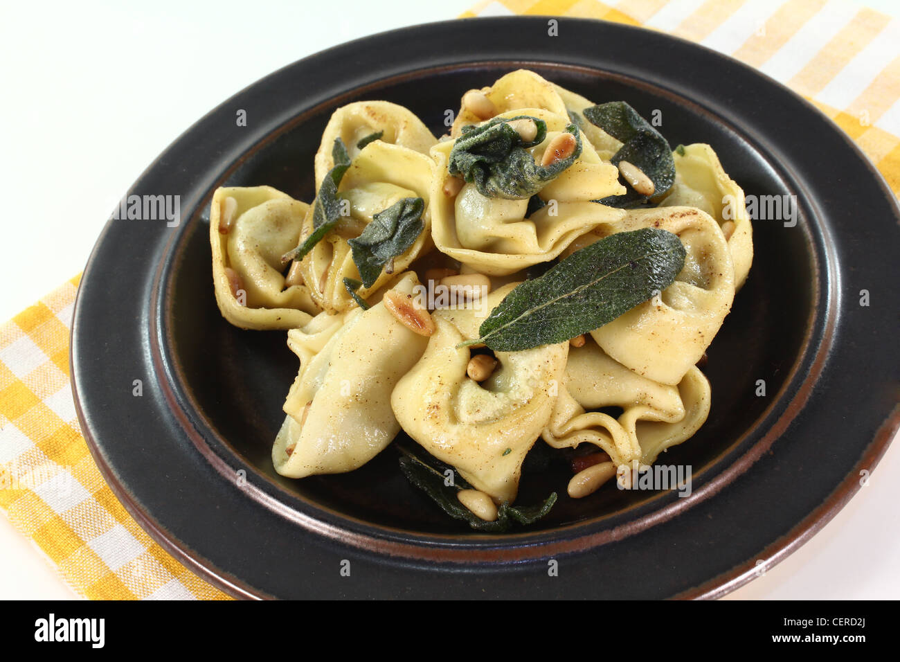 Rucola-Ricotta gefüllte Tortellini mit frischen Salbeibutter und Pinienkernen Stockfoto