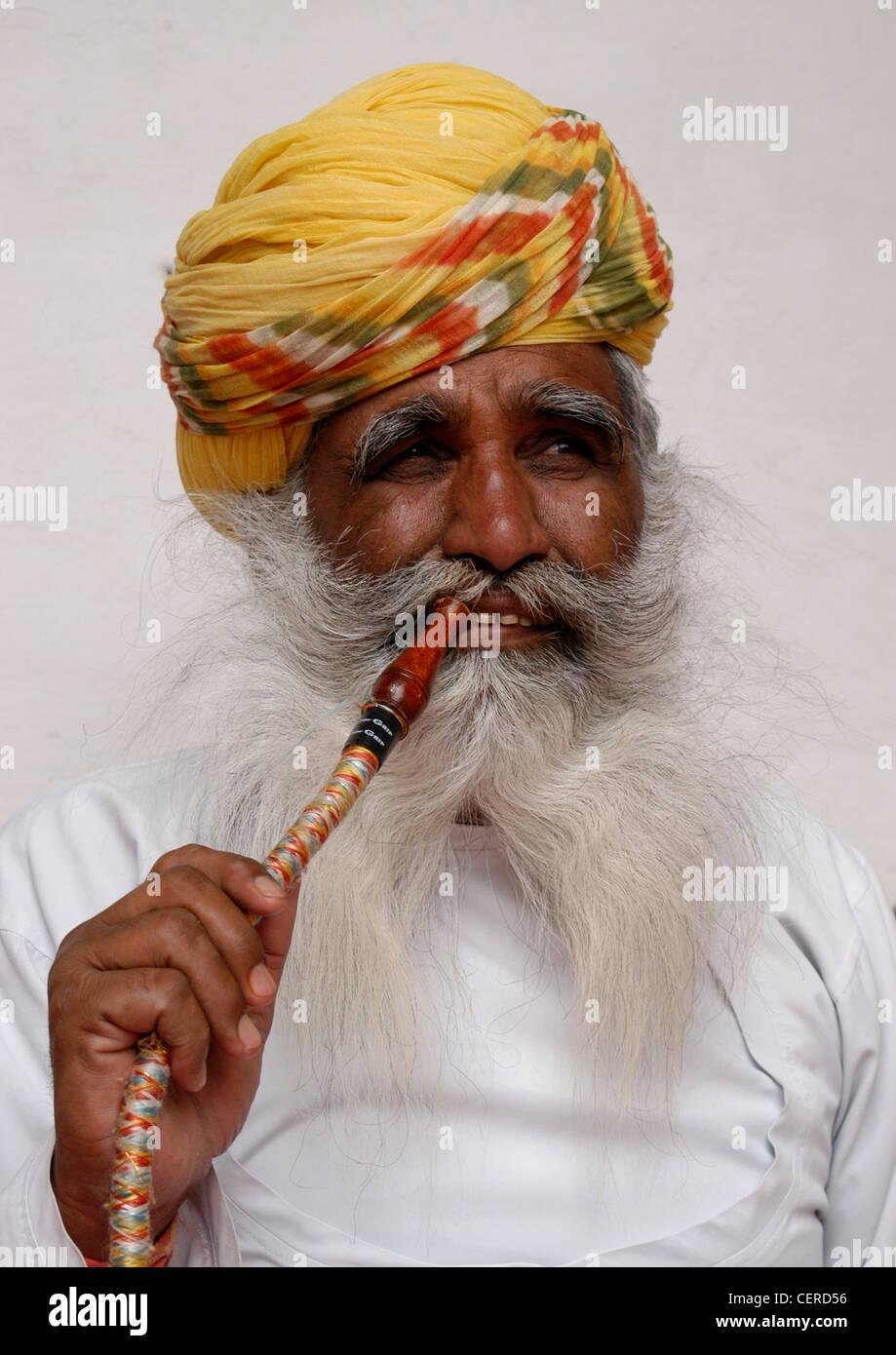 Rajput-Mann vertreten Rajasthani Königreich zeigt Methode des Rauchens gefilterte Tabakrauch durch Shisha Rohr für Entspannung. Stockfoto