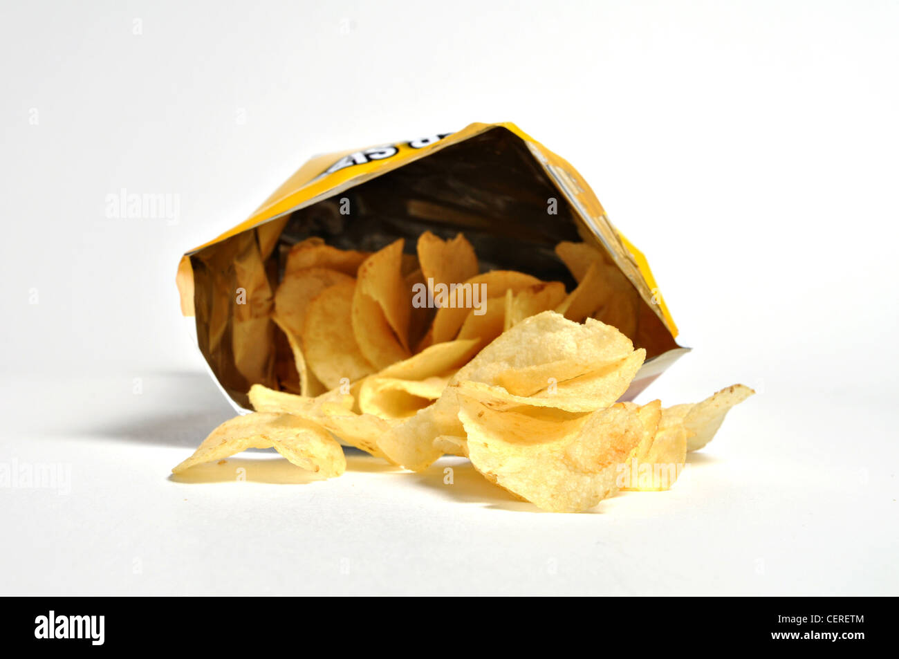 Ein Beutel der Kartoffelchips legt sich auf die Seite mit Chips verschütten draußen auf seiner Seite. Stockfoto