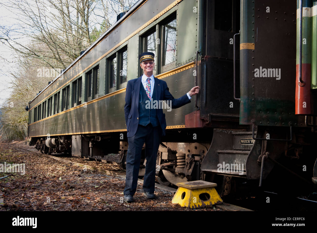 Ein Dirigent auf der Lake Whatcom Bahn begrüßt Passagiere an Bord der antiken Schiene Pkw. Stockfoto