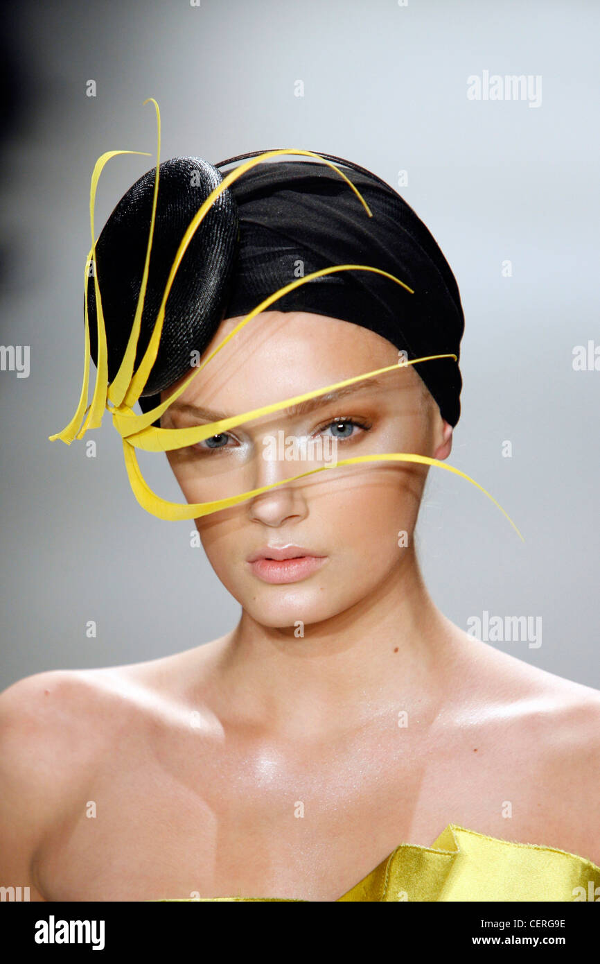 Donna Karan New York Accessoires Herbst Wintermodell mit schwarzen Turban Stroh Hut auf Vorderseite des Kopfes und gelb geformt Stockfoto