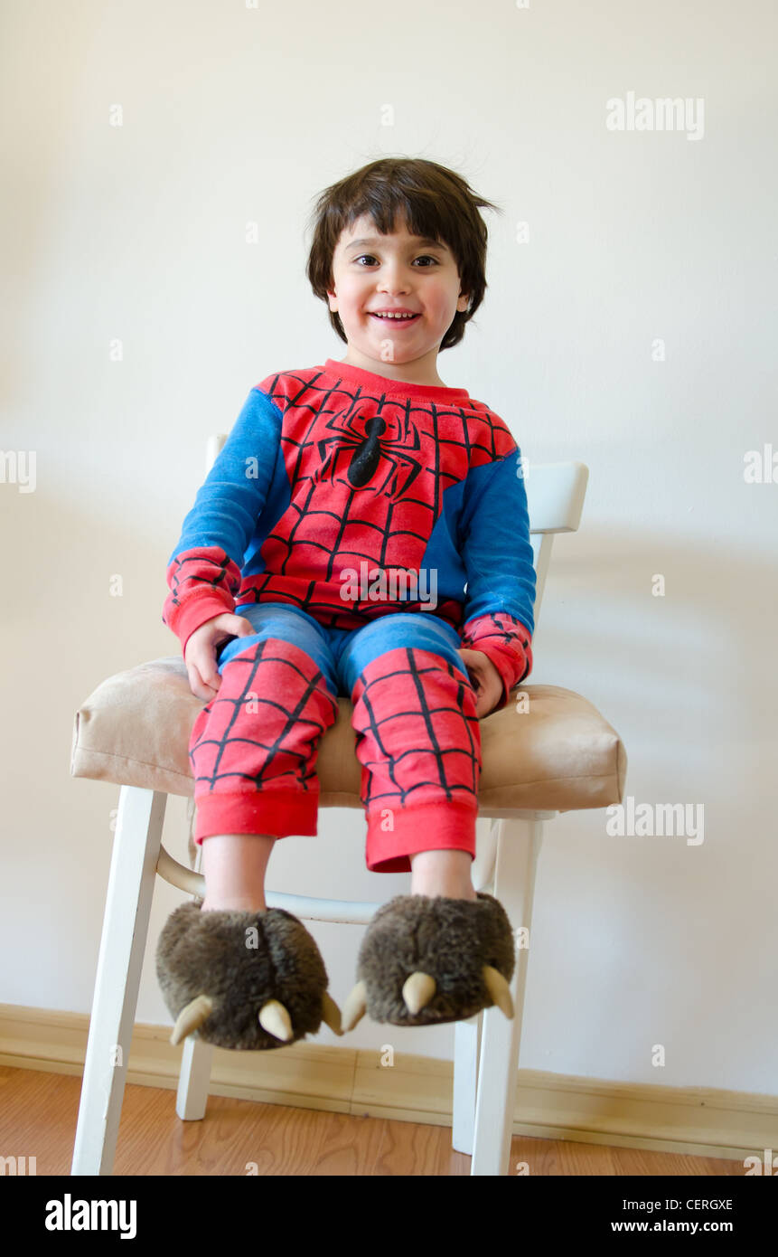 Ein Kleinkind, das Lächeln auf den Lippen tragen eine Spider-Man Pyjama auf  einen weißen Stuhl sitzend Stockfotografie - Alamy