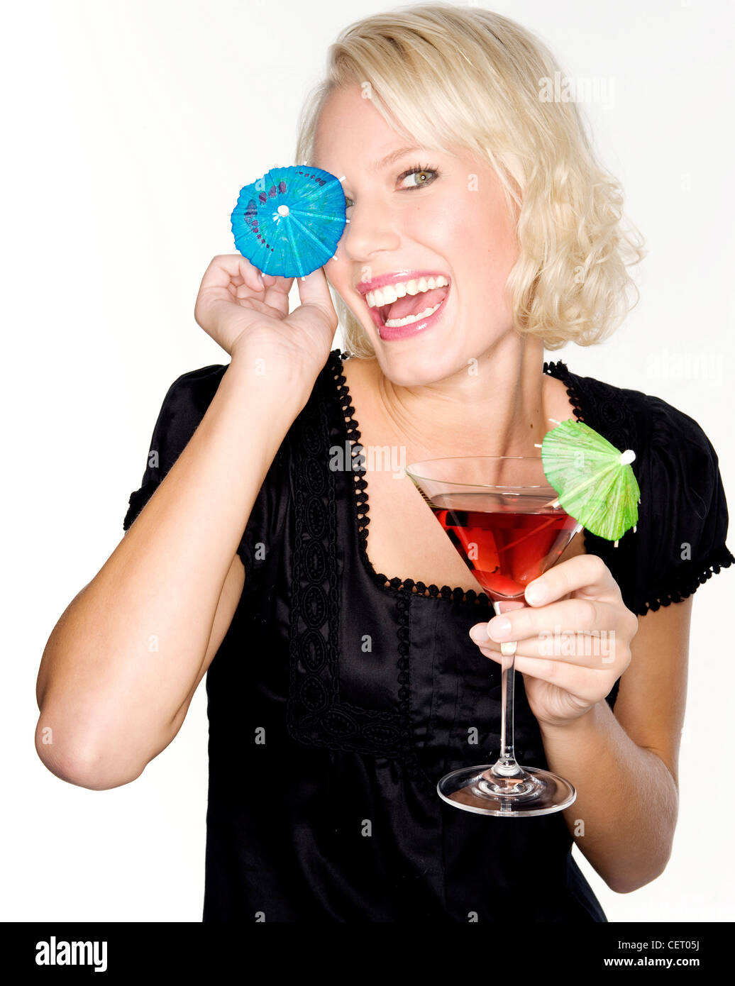 Weiblich, einem roten Cocktail in einem Martini cocktail Glas, ein Grünbuch Regenschirm dekorieren das Glas, und hält eine blaue Stockfoto