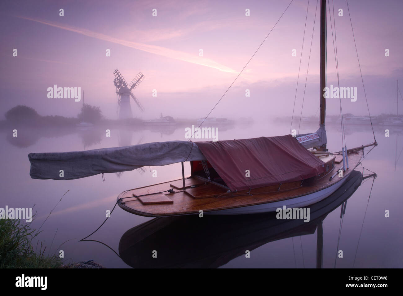 Eine neblige Sicht über das Wasser zu Thurne Mill bei Sonnenaufgang. Stockfoto