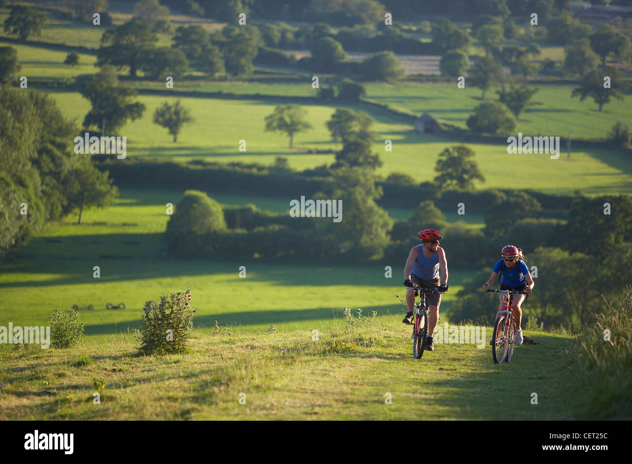 Mann & Frau auf dem Mountainbike Radfahren auf Hambledon Hill über die Blackmore Vale, Dorset, England, UK Stockfoto