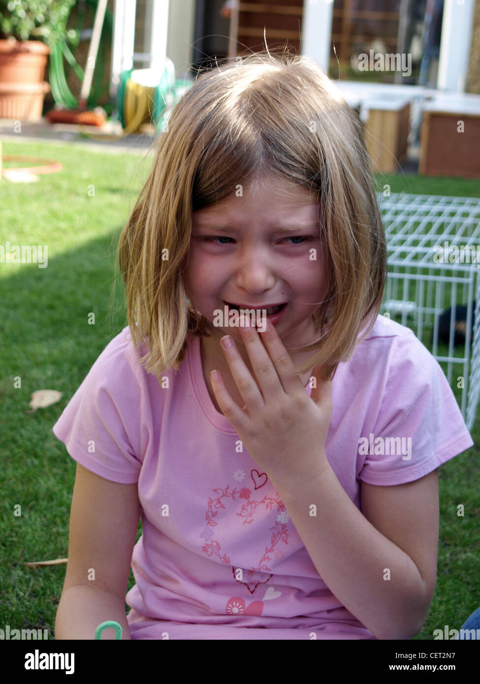 Weibliches Kind mit dunkel blondes schulterlanges Haar, trägt eine rosa  t-Shirt, Weinen Stockfotografie - Alamy