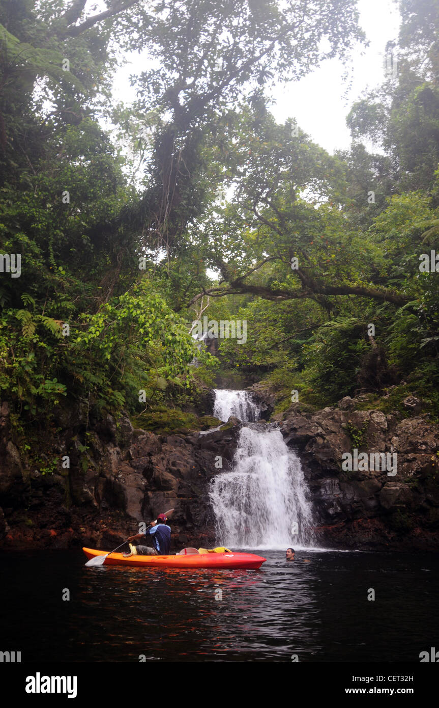 Touristische und Guide mit Kajak am Wasserfall, Lavena Coastal Walk, Bouma National Heritage Park, Taveuni, Fidschi. Weder Herr PR Stockfoto