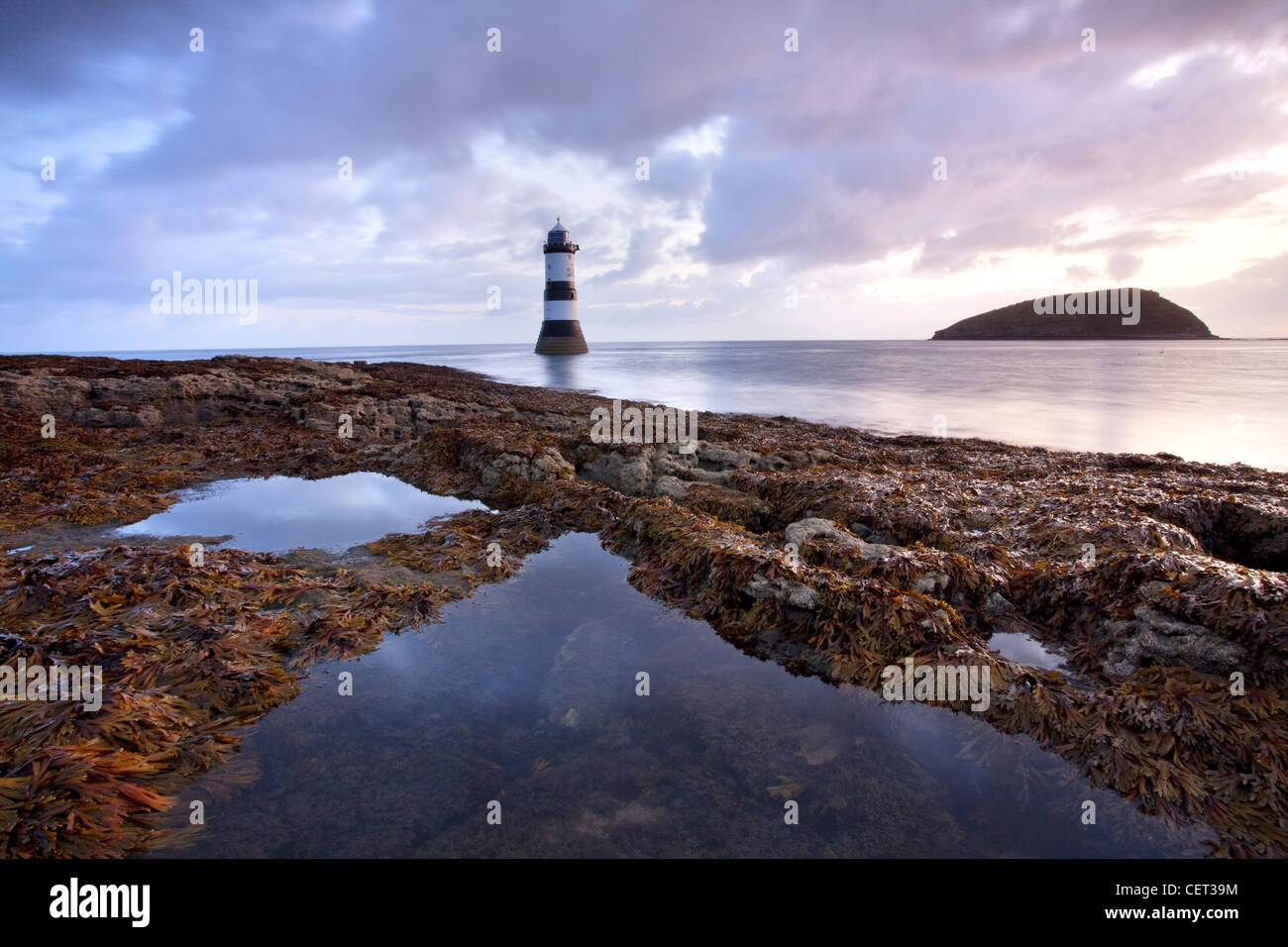 Ein Blick auf Penmon Leuchtturm und Puffin Island in der Morgendämmerung auf der Küste von Anglesey in Nord-Wales. Stockfoto