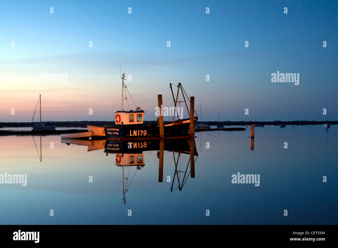 Angelboote/Fischerboote spiegelt sich in stillem Wasser in der Nacht an der Küste von Norfolk. Stockfoto