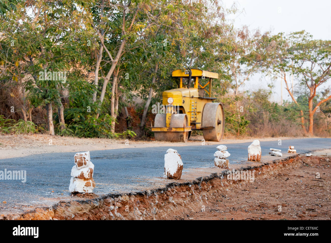 Ländliche indische Straßenbau mit Dampfwalze im Hintergrund. Andhra Pradesh, Indien Stockfoto