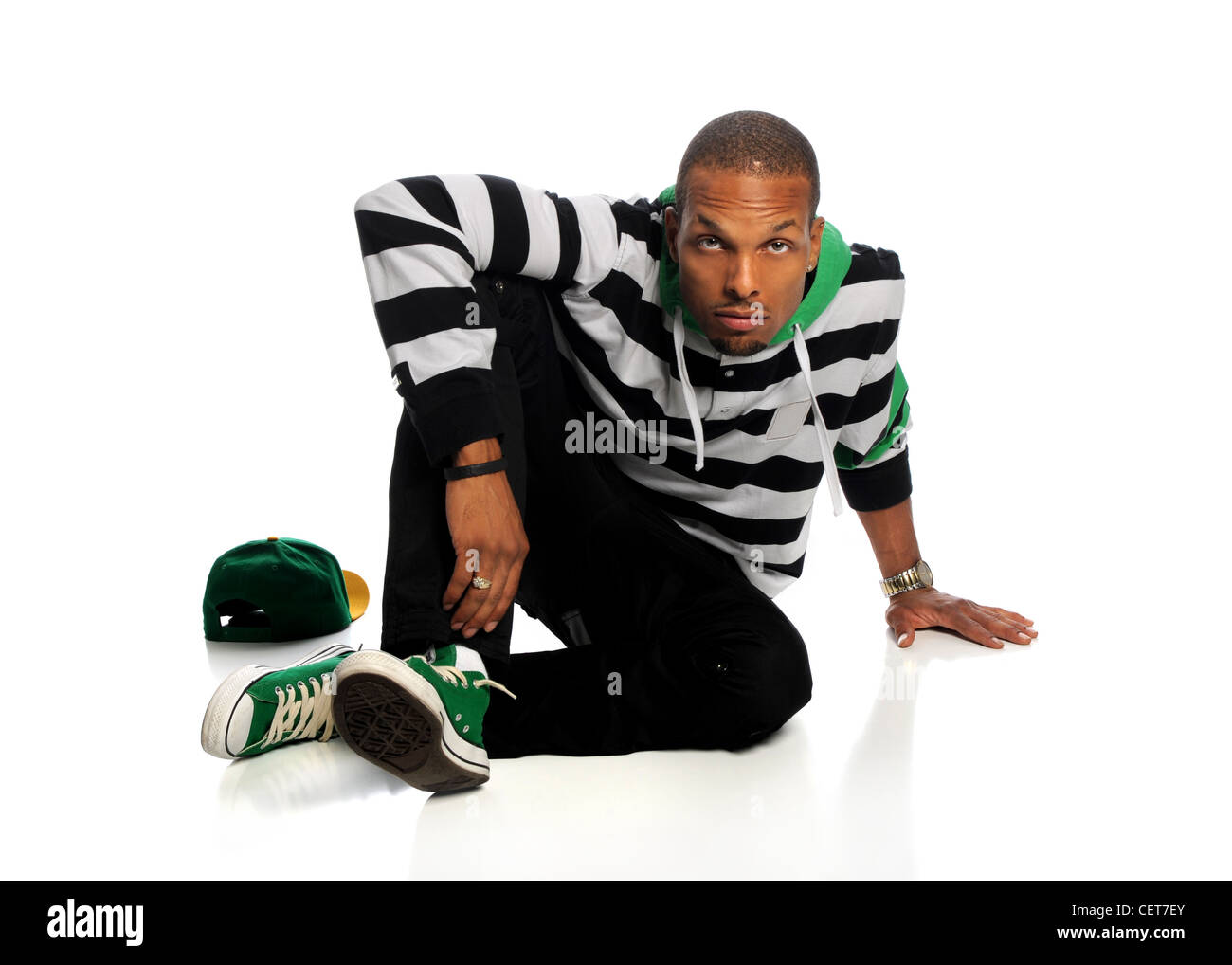 Porträt des afroamerikanischen Hip-Hop-Mann sitzt isoliert auf weißem Hintergrund Stockfoto