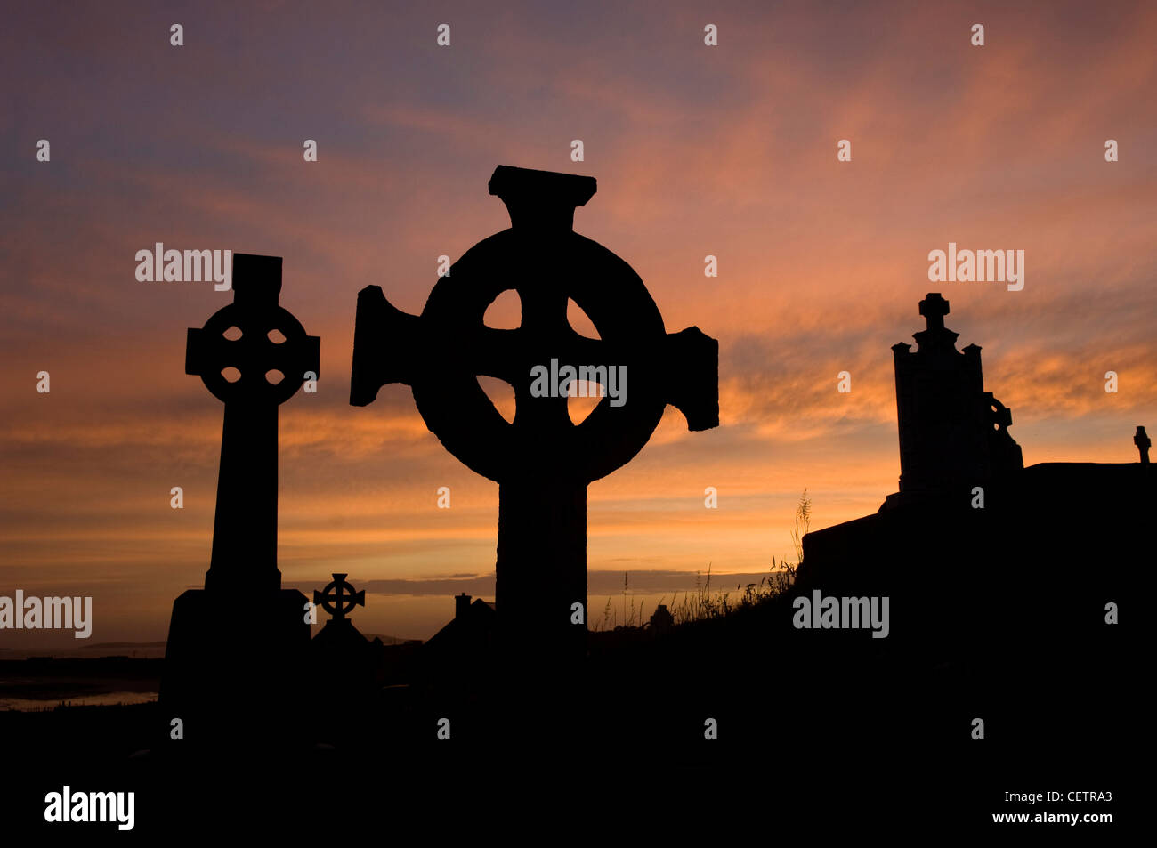 Keltisches Kreuz in Friedhof bei Sonnenuntergang Stockfoto