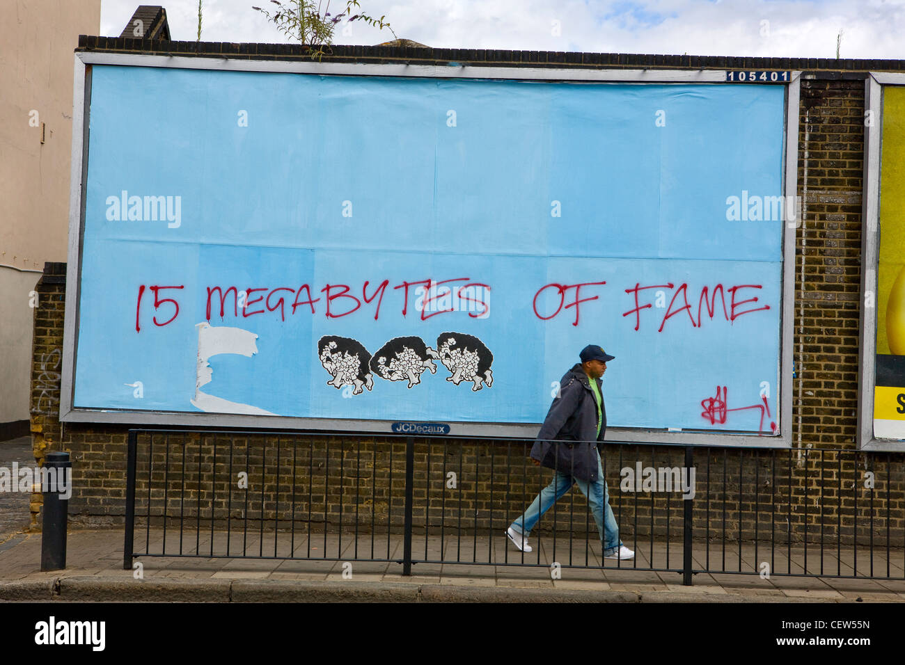 Mann zu Fuß vorbei an "15 Megabyte Ruhm Graffiti", Hackney, London Stockfoto