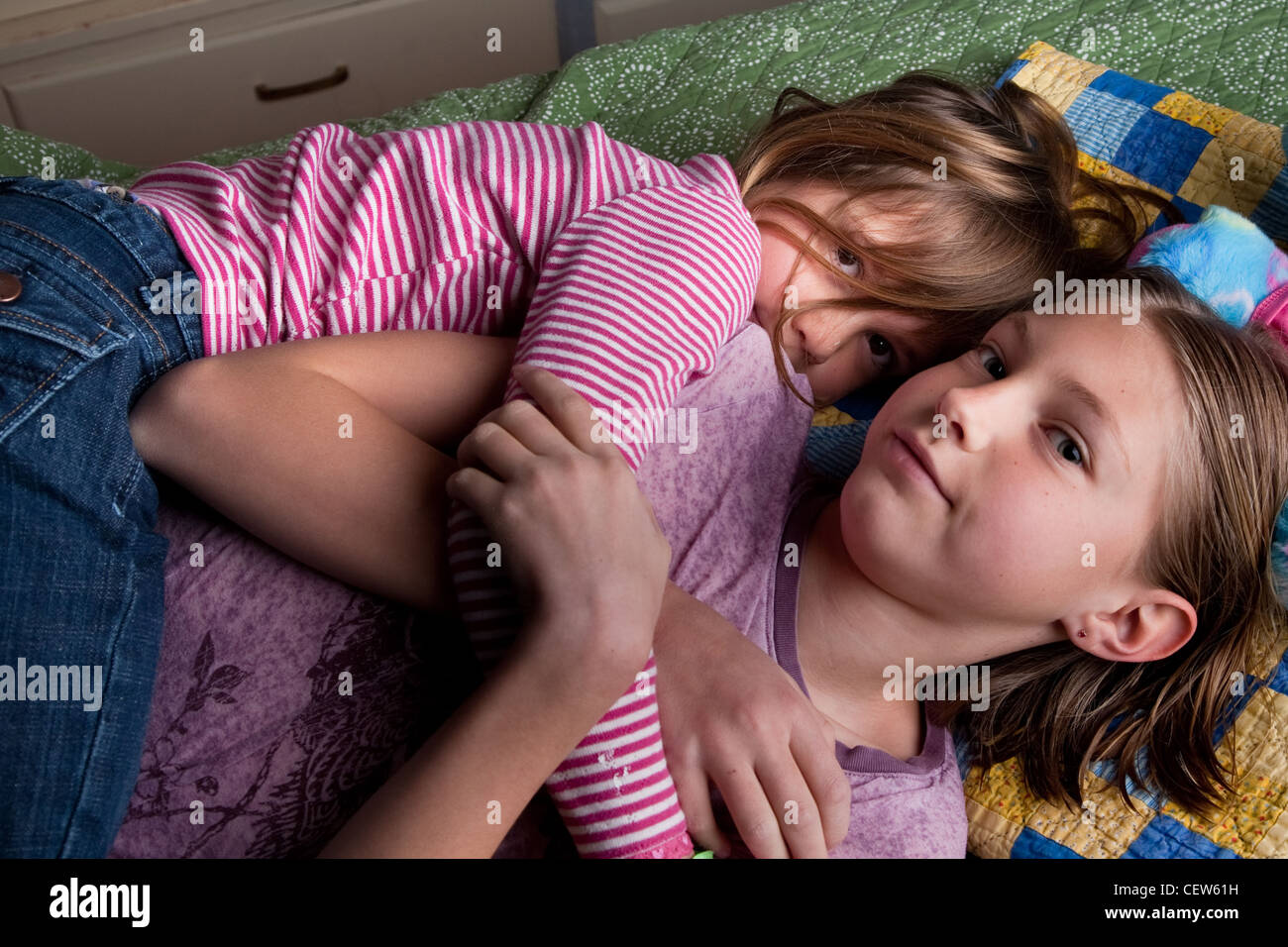 Zwei Schwestern einander auf dem Boden zu Hause kuscheln. Stockfoto