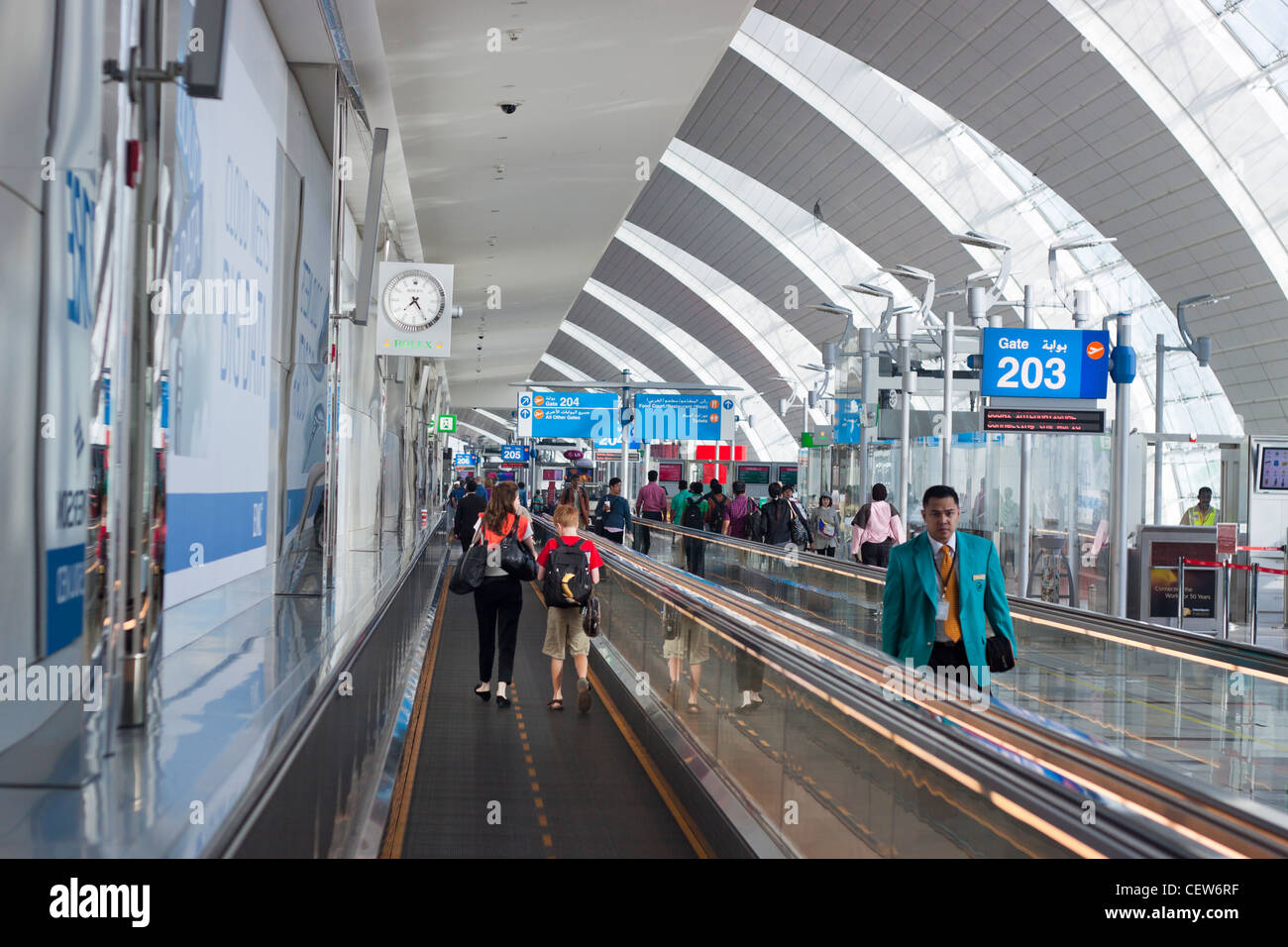 Menschen gehen durch den Flur der Flughafen Dubai International Airport, Dubai, Vereinigte Arabische Emirate. Stockfoto