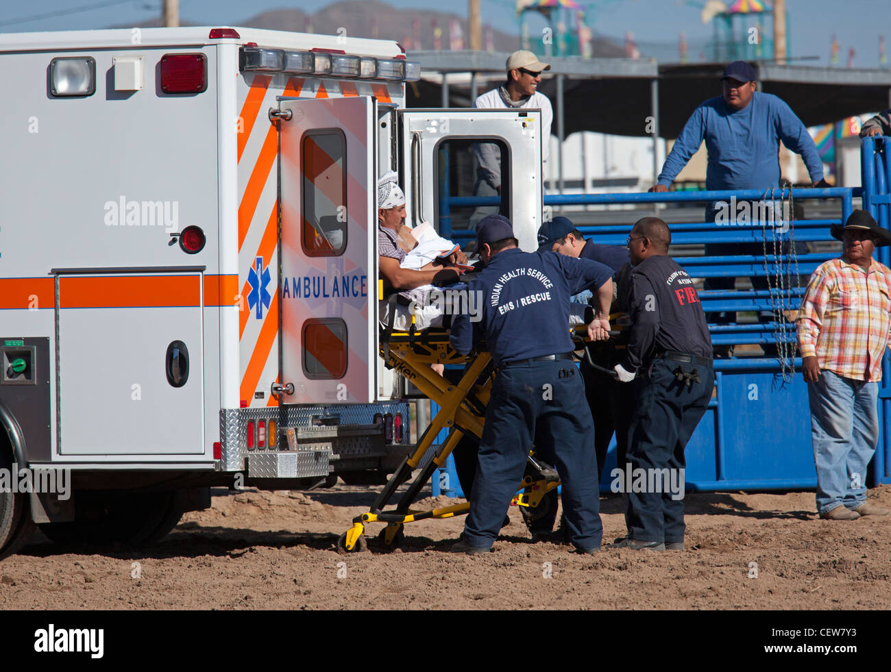 EMS-Arbeiter helfen Mann verletzt im Bullenreiten Wettbewerb bei All-indischen Rodeo Stockfoto