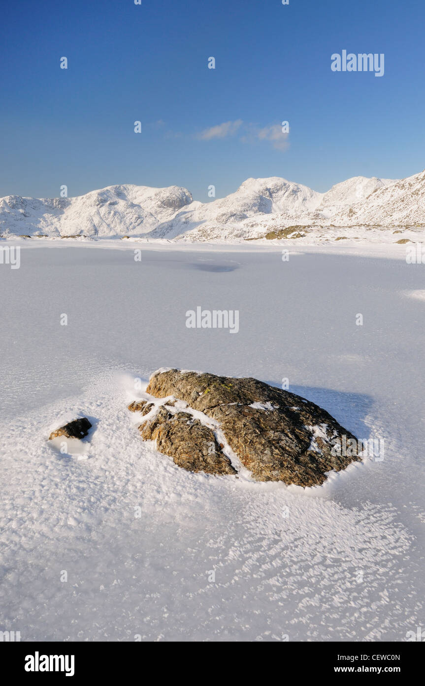 Rock und gefrorenen drei Bergseen, mit Schnee verkleidet Scafell und Scafell Pike im Hintergrund, englischen Lake District Stockfoto