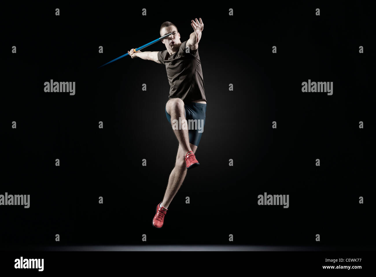 Männliche Athleten springen mit Speer Stockfoto