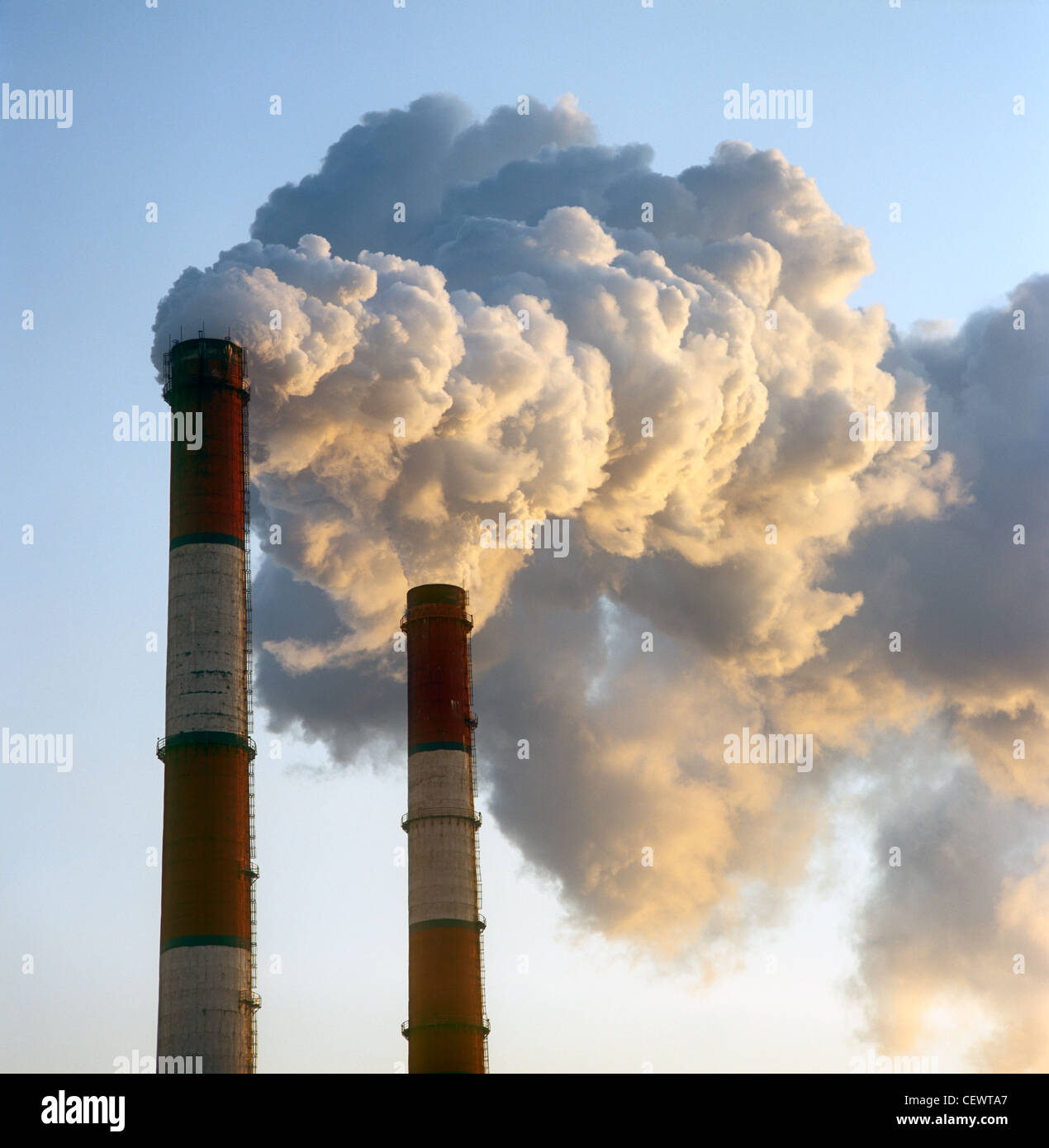 Luftverschmutzung durch Rauch aus zwei Fabrikschornsteine. Stockfoto