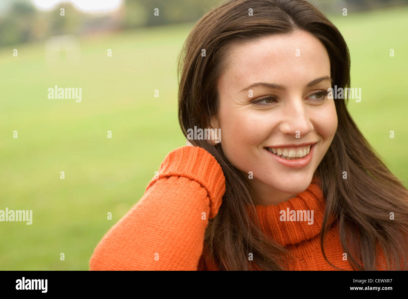 Frauen tragen orange Rollkragen Pullover mit Hand Nacken Stockfoto