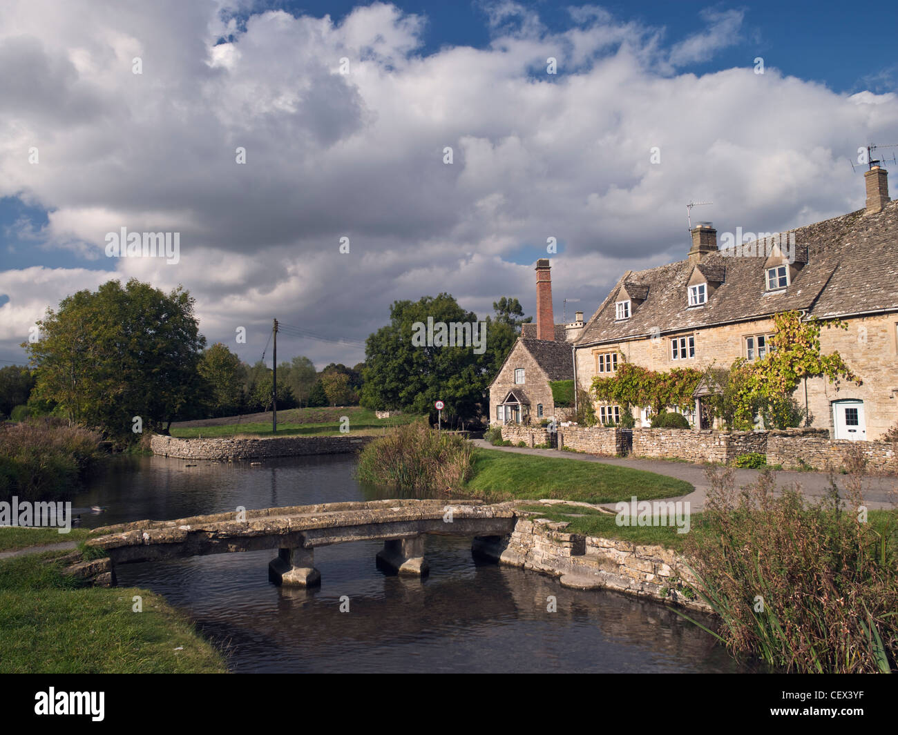 Ein Klöppel Brücke über den Fluss-Auge und die alte Mühle in Lower Slaughter. Stockfoto