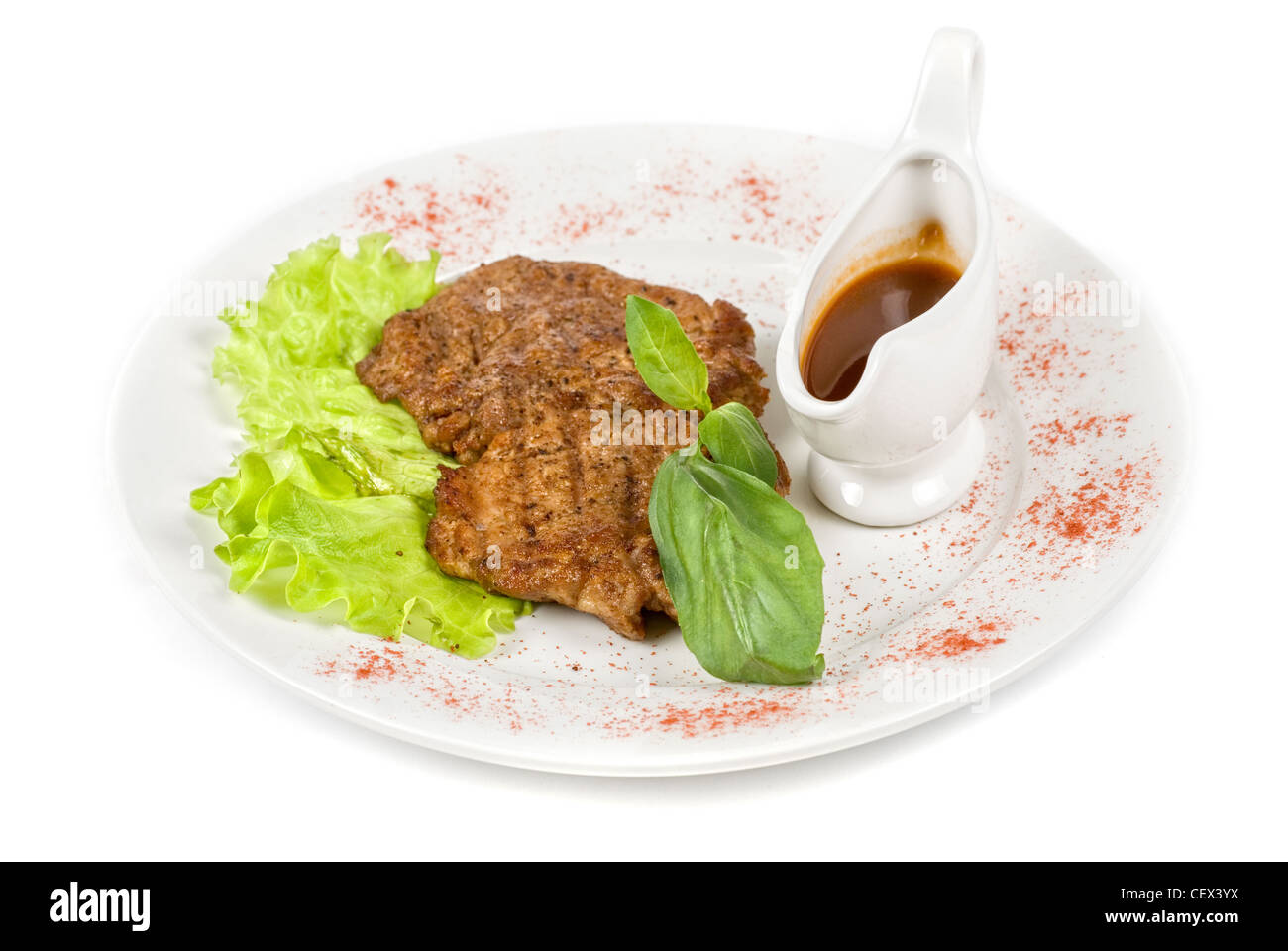 Gebratene Schweineschnitzel auf den weißen Teller mit Gemüse und Soße Stockfoto