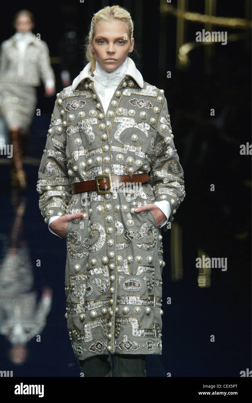 Dolce und Gabbana bereit zu tragen Mailand A W Blondine weibliches Modell trägt einen grauen Mantel silbernen Knöpfen und silbernen Applikationen detail Stockfoto