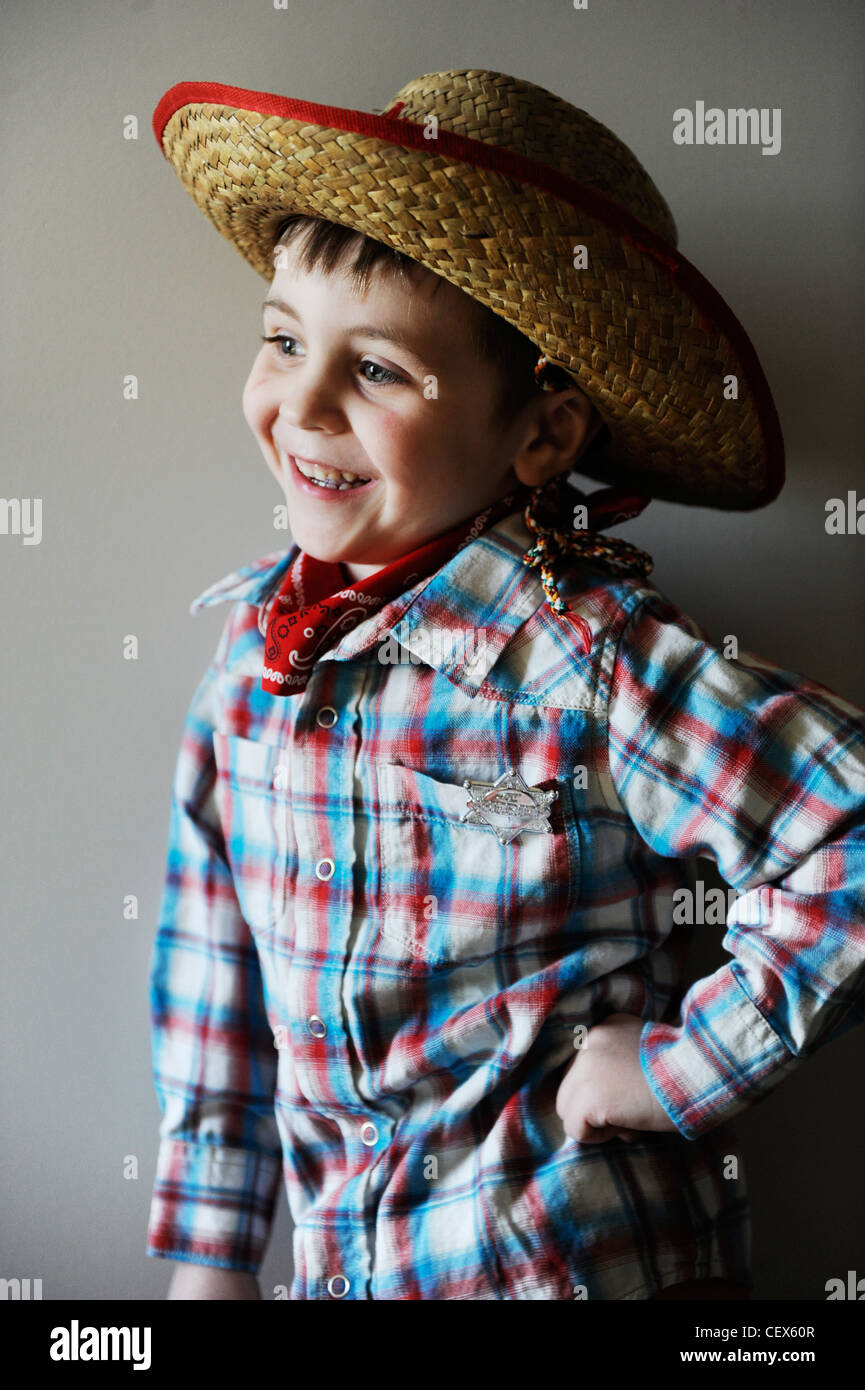 Lächelnde junge 4 Jahre alt in Cowboy-Flanell-Kostüm mit braunen Hut wegsehen von Kamera Stockfoto