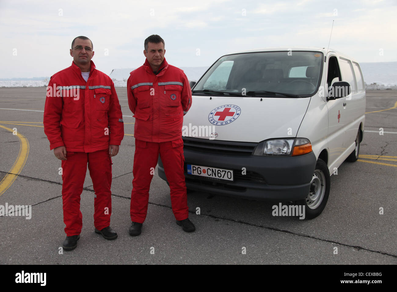 PODGORICA, Montenegro -- Rotes Kreuz Personal steht mit Vorräten zur Verladung in einem UH-60 A+ Black Hawk Hubschrauber am 22. Februar 2012. Die Soldaten sind hier als Teil einer US-Task Force, um humanitäre Hilfe auf Antrag der Regierung von Montenegro, die mit dem Nationalen Noteinsatzzentrum und dem montenegrinischen Verteidigungsministerium koordiniert, zu leisten, um Hilfe zu leisten und Leben, Häuser und Infrastruktur als Reaktion auf starken Schneefall zu retten. Stockfoto