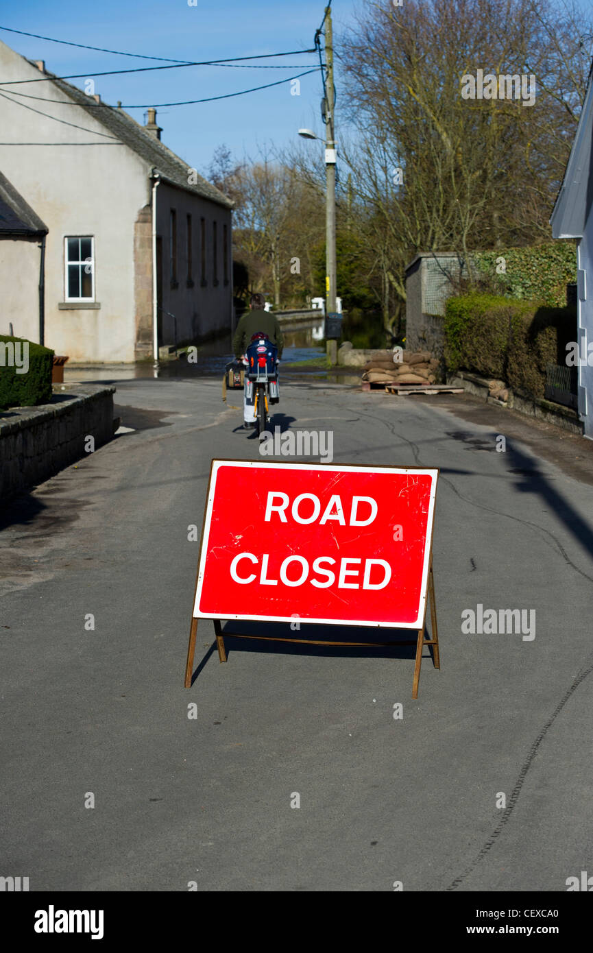 Mann reitet vorbei Straße gesperrt-Schild für die Flutung des River Spey in Garmouth, Schottland im April 2010 aufgrund starker Schneefälle schmelzen. Stockfoto