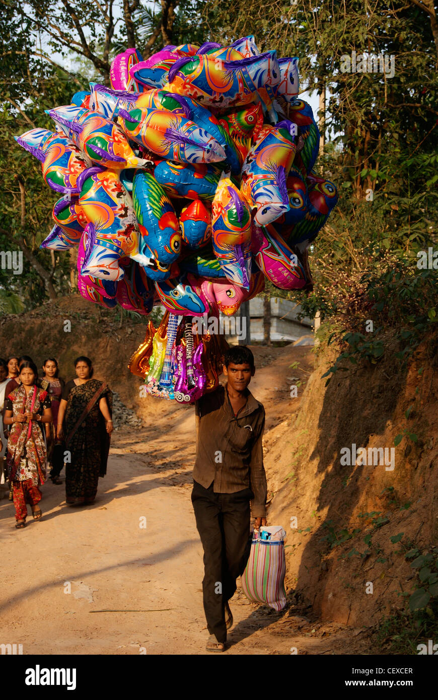 Ballon-Verkäufer in Dorfstraßen während Tempelfest. Eine Szene aus Kerala, Indien Stockfoto