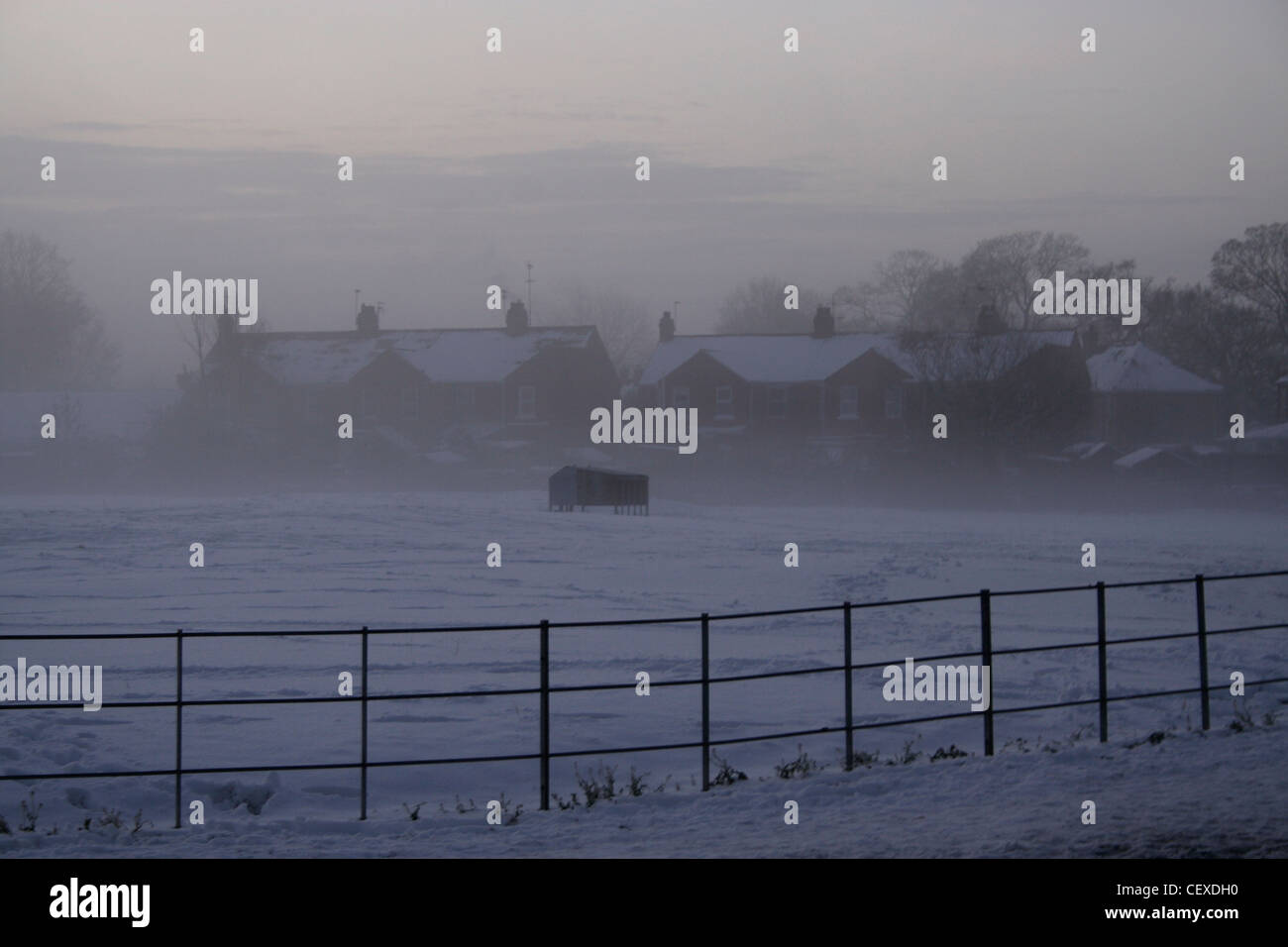 Schnee und Nebel Sonnenaufgang über Feld und Dächer Minster Yard Süden Beverley am frühen Morgen rosa Himmel Stockfoto