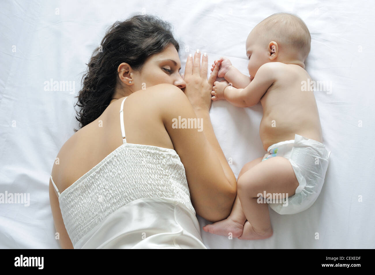 Baby schläft in der Nähe ihrer Mutter, mit ihrem finger Stockfoto