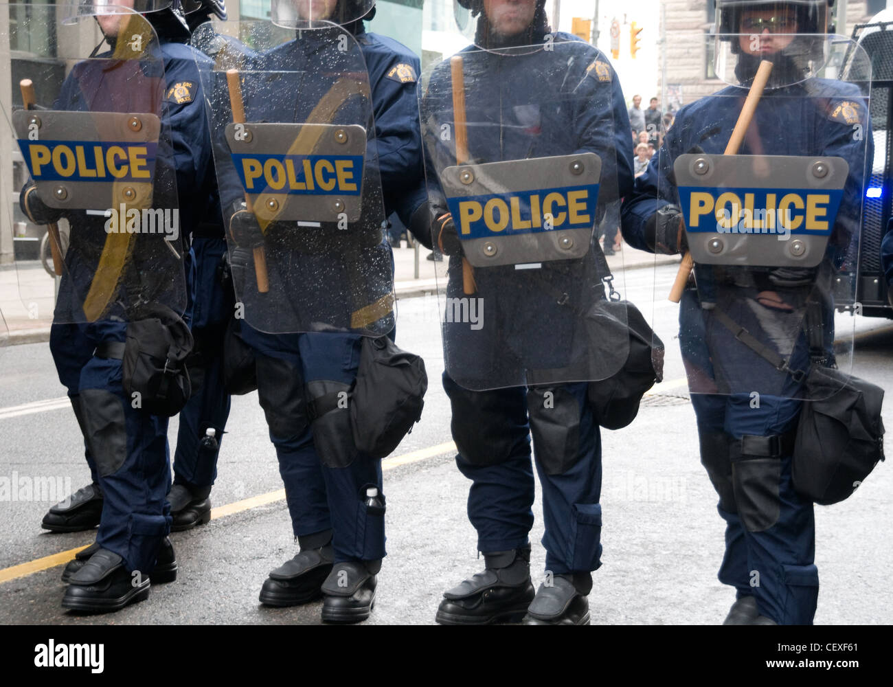 RCMP Bereitschaftspolizei gegenüber Demonstranten mit Schilden und Schlagstöcken auf einer Straße der Innenstadt während der G20-Gipfel im Jahr 2010, Toronto, Ontario, Kanada. Stockfoto