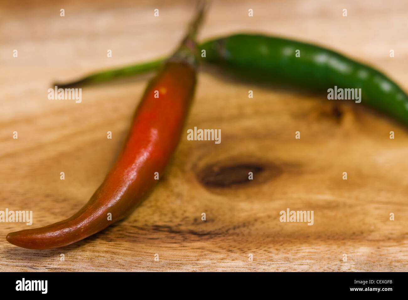 Rote und grüne Chilischoten auf Holzbrett Stockfoto